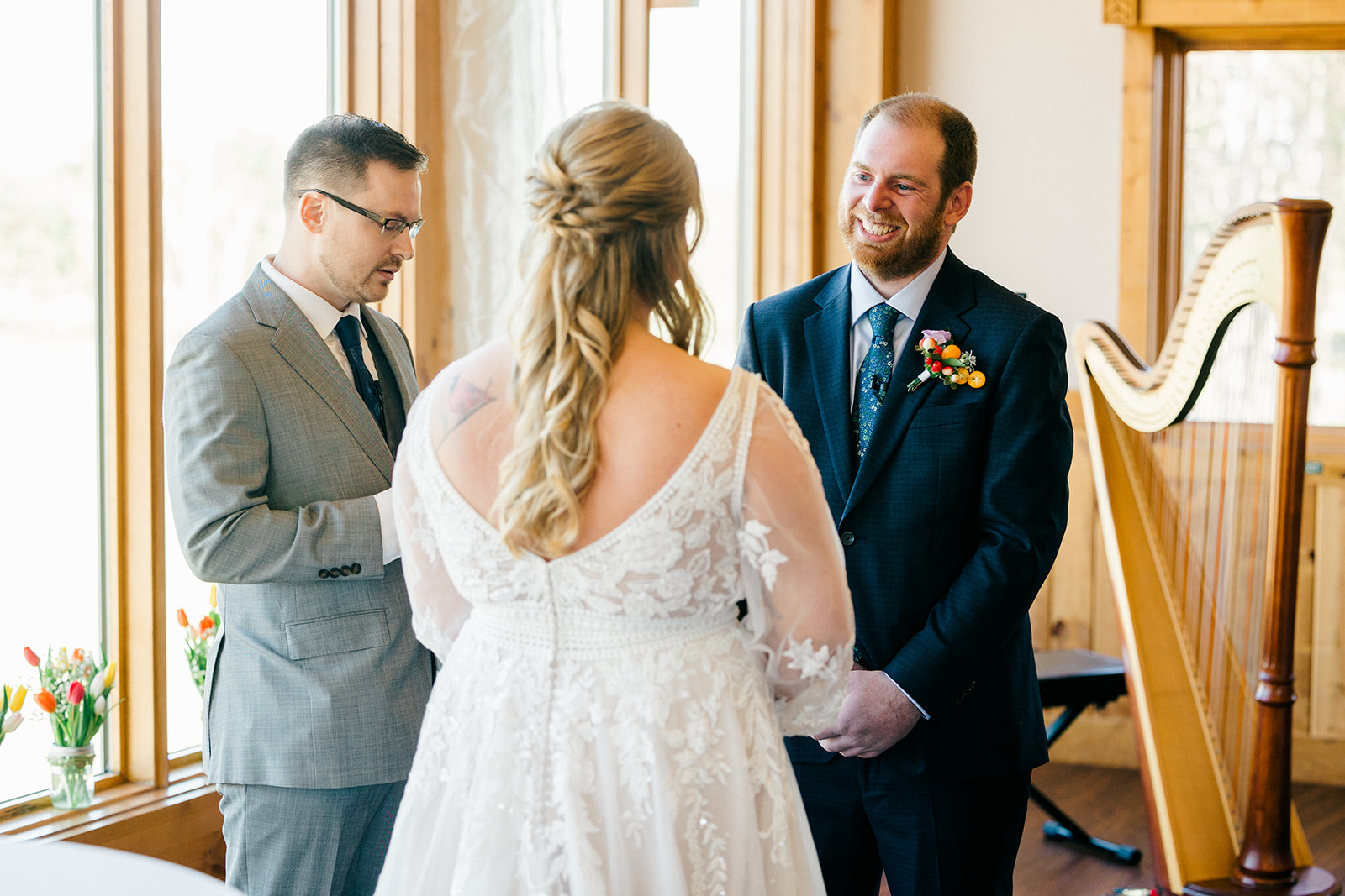 Groom's expression as the bride approaches during the Audubon Room ceremony — harp visible in background — Tim Larsen Photography, Brainerd Lakes MN