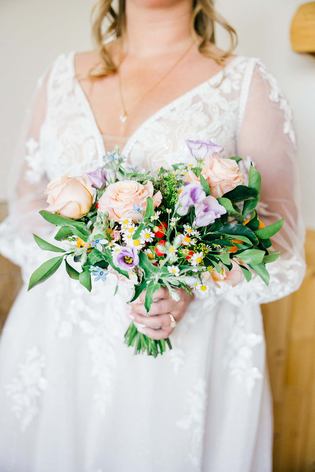 Bridal bouquet of peach roses, daisies, purple wildflowers, and greenery — garden-style arrangement — Tim Larsen Photography, Brainerd Lakes MN