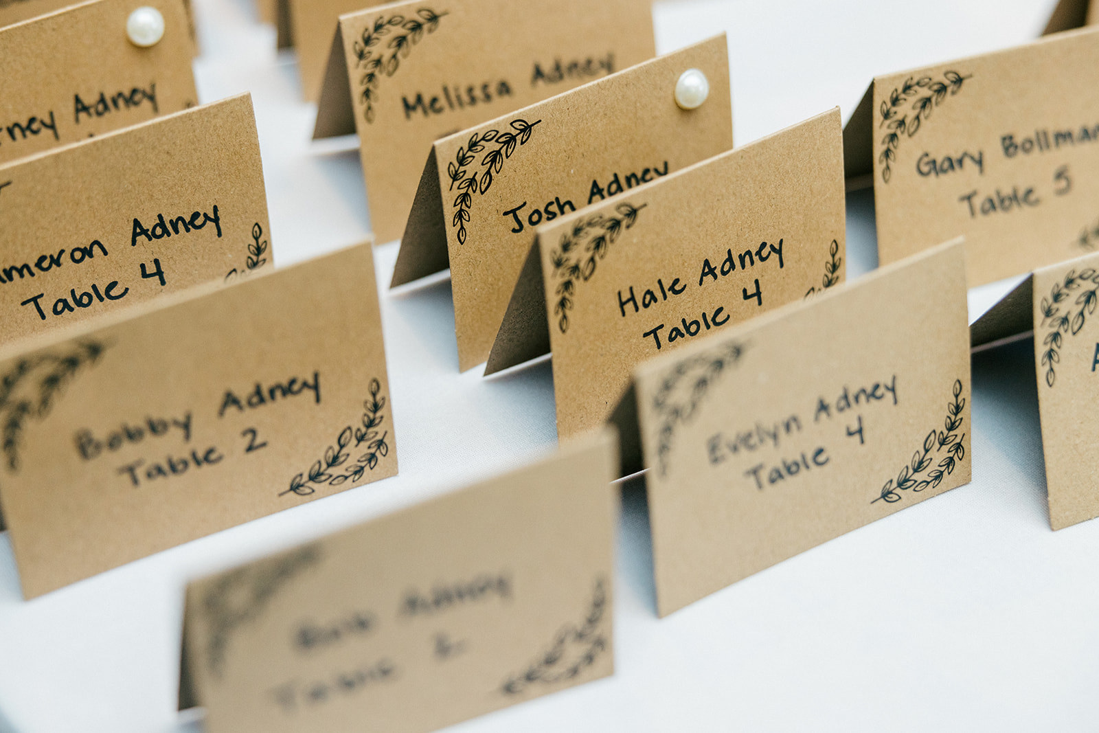 Hand-lettered kraft paper escort cards arranged in rows for the Cragun's Legacy reception — Tim Larsen Photography, Brainerd Lakes MN