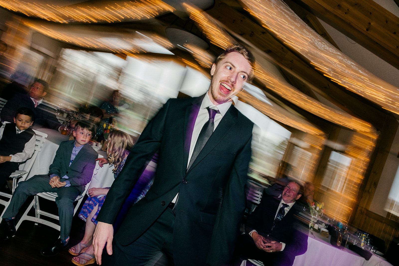 Guest dancing with energy on the reception floor, motion blur capturing the movement of the night — Tim Larsen Photography, Brainerd Lakes MN