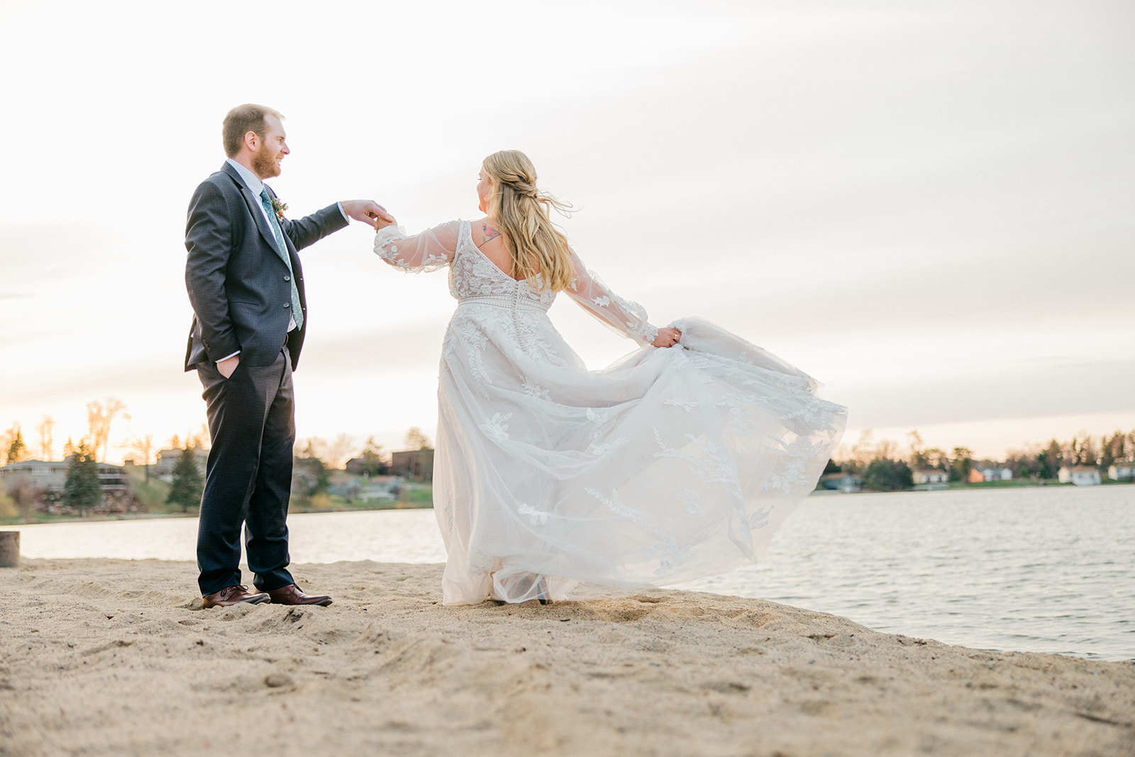 Bride spinning on the sandy Gull Lake beach at sunset, lace dress and tulle skirt catching the breeze — Cragun's Legacy Golf Course — Tim Larsen Photography, Brainerd Lakes MN