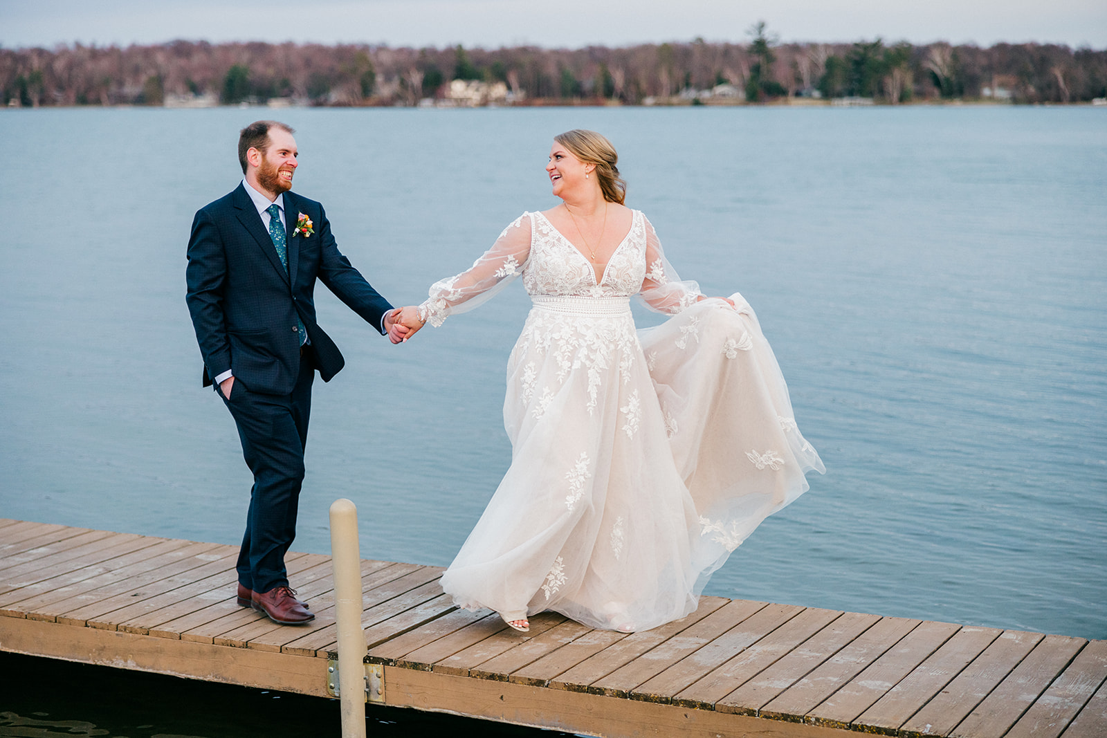 Bride and groom walking the Gull Lake dock at dusk, dark blue water behind them — Tim Larsen Photography, Brainerd Lakes MN — Tim Larsen Photography, Brainerd Lakes MN