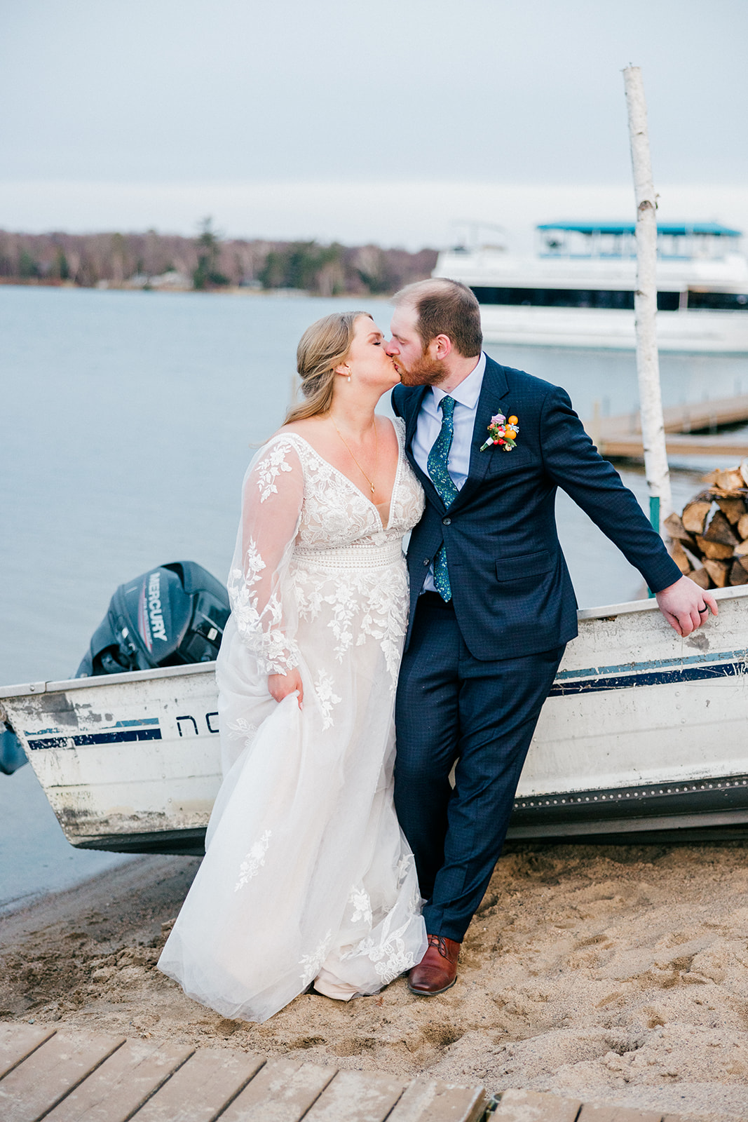 Couple kissing near an old wooden boat on the Gull Lake shoreline at Cragun's Legacy, blue-hour light — Tim Larsen Photography, Brainerd Lakes MN