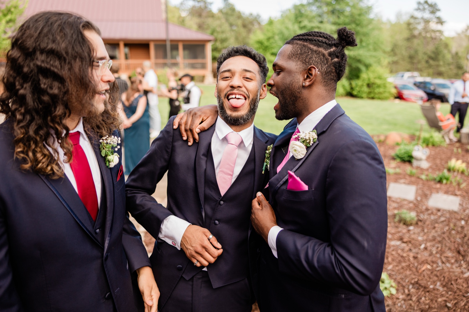 Groomsmen horsing around with the groom on the lawn between the ceremony and portraits