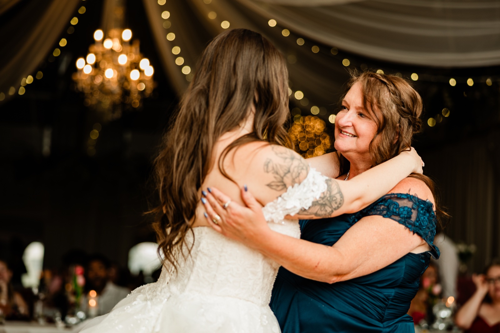 Mother-daughter dance beneath the chandeliers and draped string lights at Pine Peaks