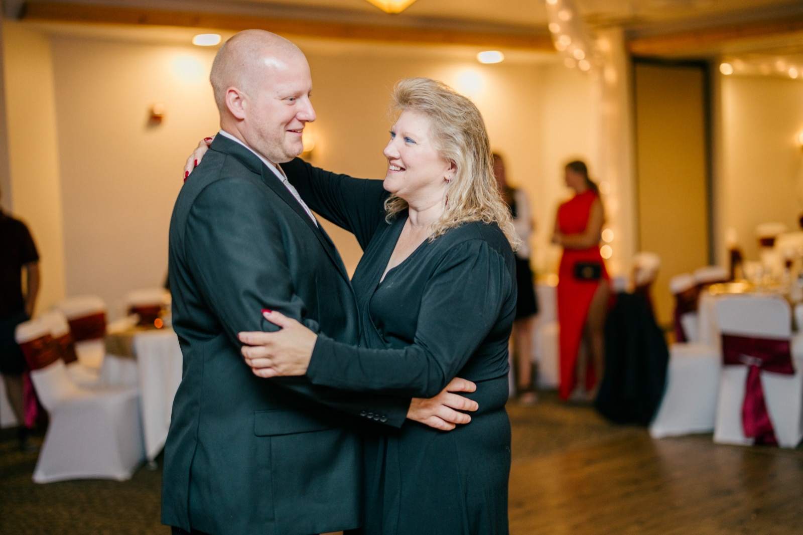 Jesse holds his mother as they share a smile during their dance on the reception floor at Whitefish Lodge — Tim Larsen Photography, Brainerd Lakes MN