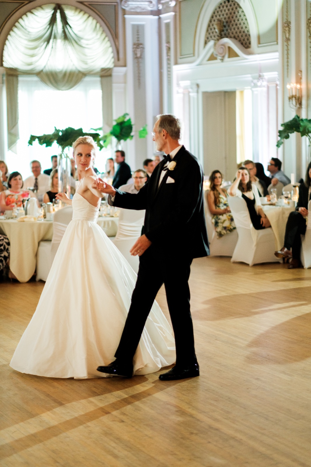 The bride dances with her father on the open wooden floor of the Greysolon Ballroom while seated guests watch from surrounding tables — Tim Larsen Photography, Duluth MN