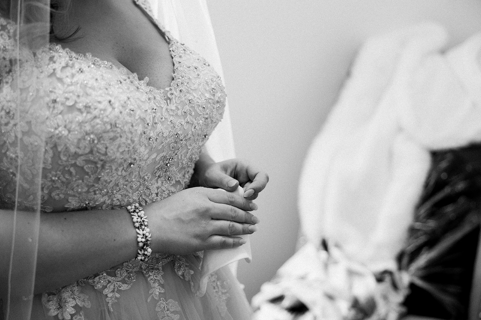 Bride clasping hands — beaded lace gown detail in black and white — Tim Larsen Photography, Brainerd Lakes MN