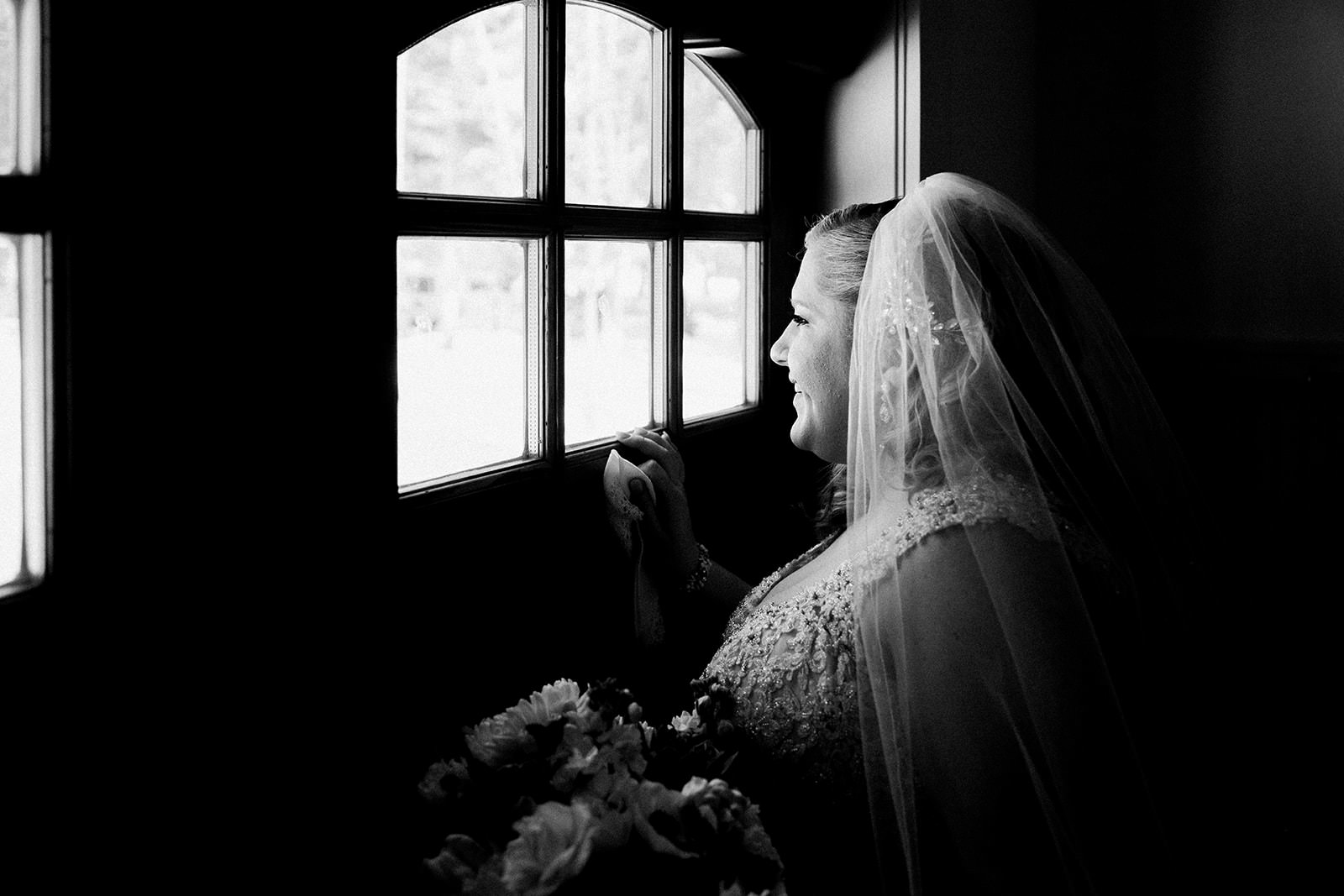 Bride looking out the window before the ceremony — black and white — Tim Larsen Photography, Brainerd Lakes MN