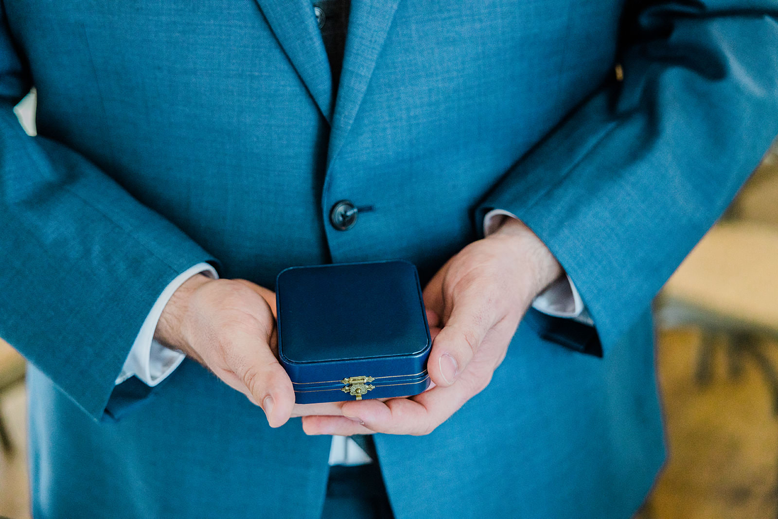 Groom holding ring box — teal suit detail — Tim Larsen Photography, Brainerd Lakes MN
