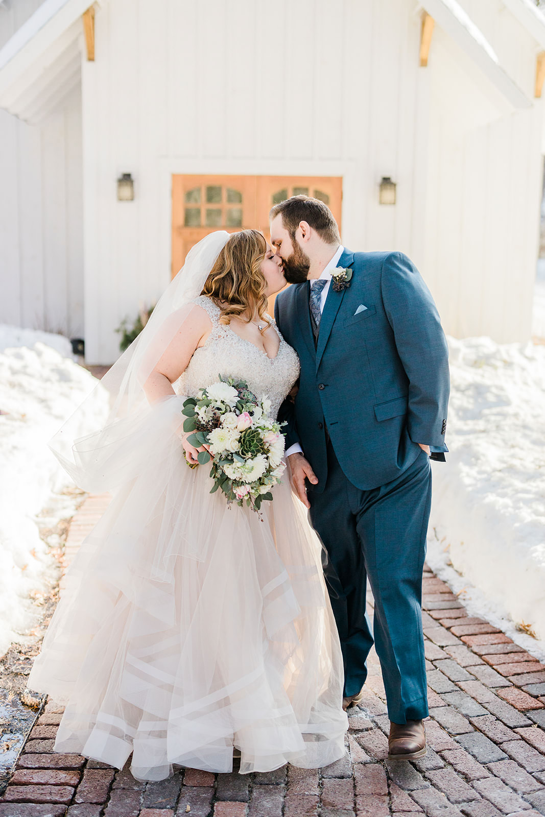 Couple kissing on the brick walkway outside The Chapel — snow-covered Grand View Lodge — Tim Larsen Photography, Brainerd Lakes MN