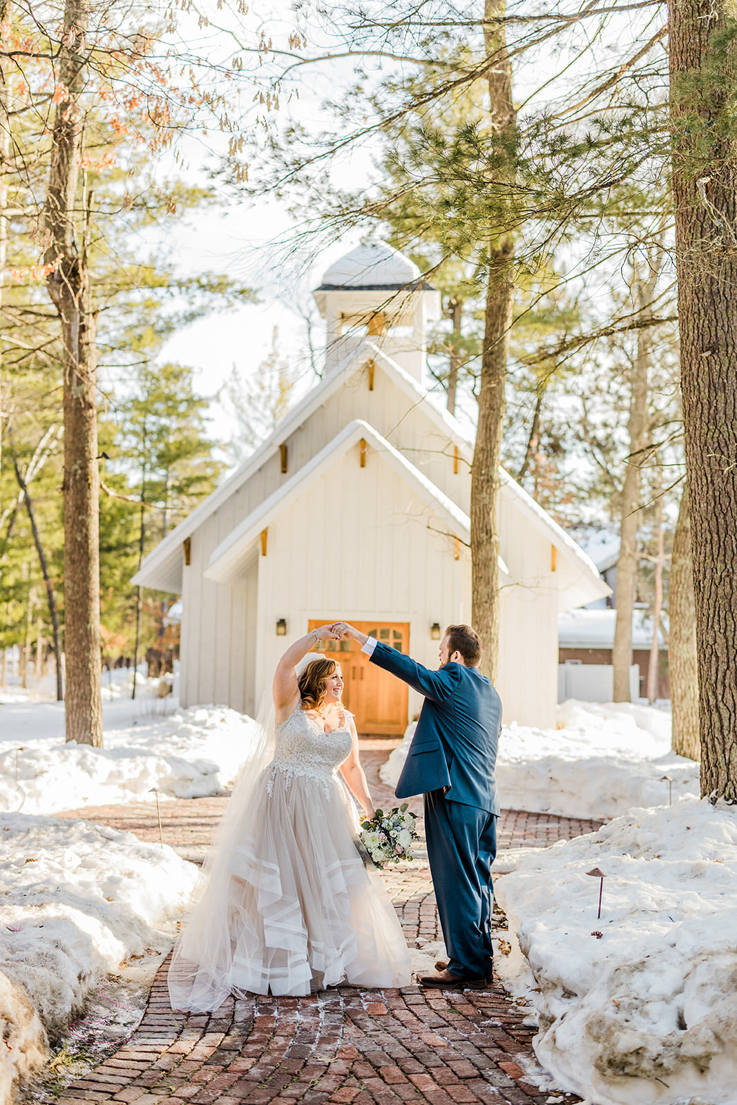 Matthew spinning Lauren in front of The Chapel — winter wedding at Grand View Lodge — Tim Larsen Photography, Brainerd Lakes MN