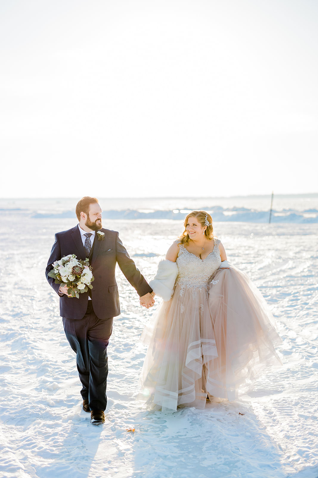 Lauren and Matthew walking on frozen Gull Lake — winter wedding portraits — Tim Larsen Photography, Brainerd Lakes MN