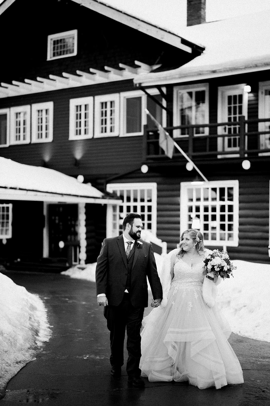 Couple walking in front of the Historic Main Lodge — black and white winter portrait — Tim Larsen Photography, Brainerd Lakes MN