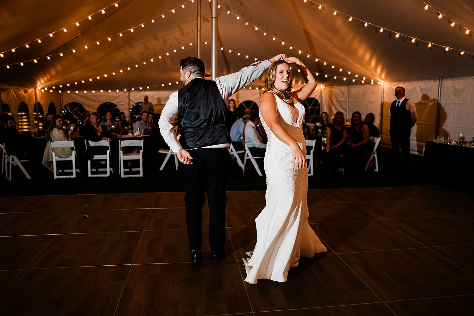 First dance under string lights in the tent — Whitefish Lake wedding reception
