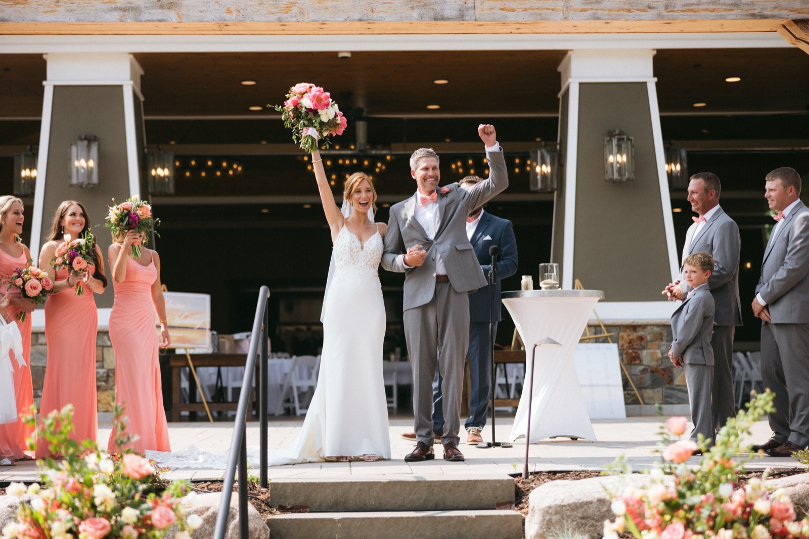 Melissa and Kody centered between the symmetrical columns of the Madden's pavilion during the recessional, bridal party flanking the edges — Tim Larsen Photography, Brainerd Lakes MN