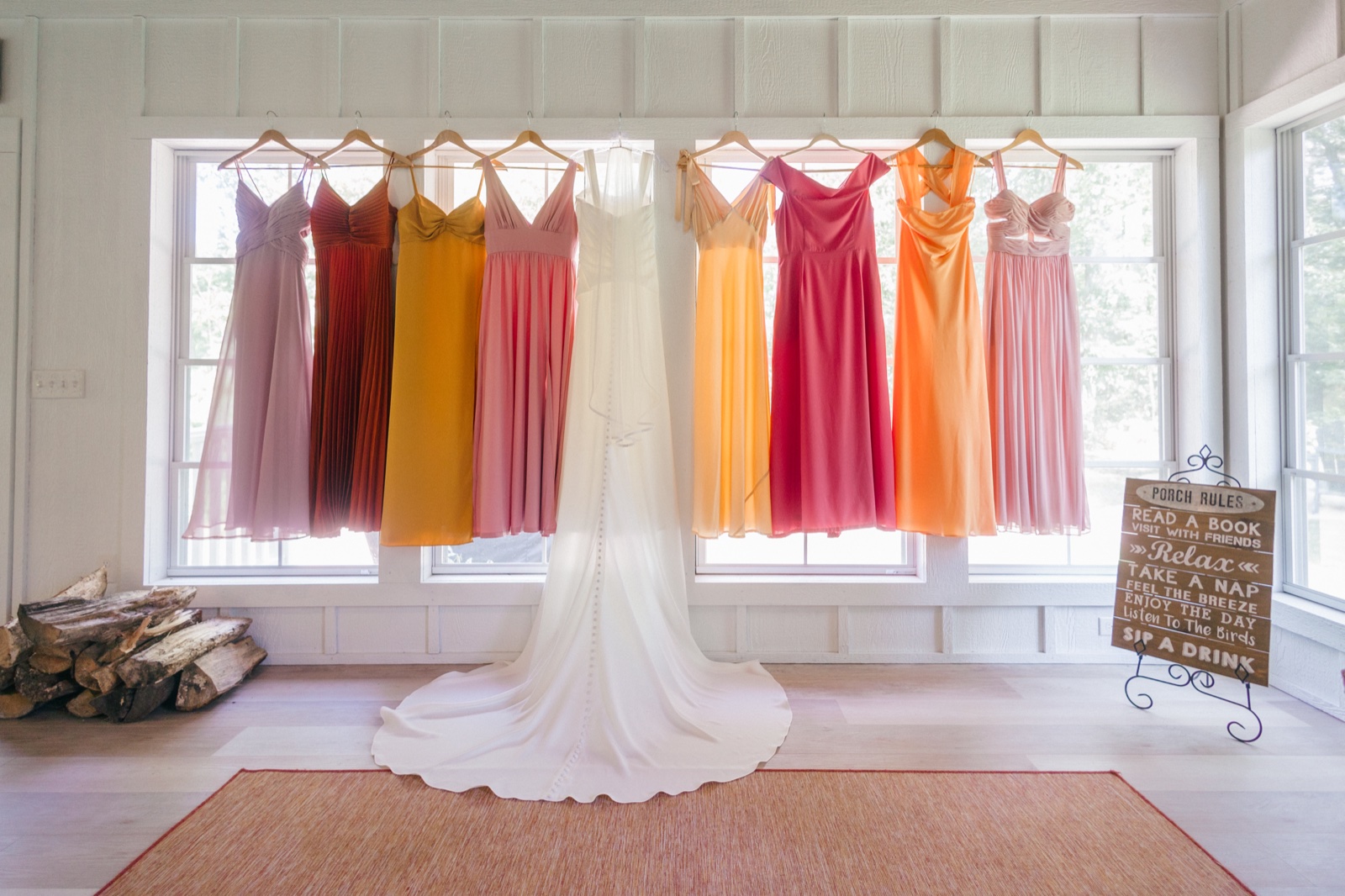 Monika's white gown anchored at the center of a row of warm-toned bridesmaid dresses across the sunlit porch at Grand View Lodge — Tim Larsen Photography, Brainerd Lakes MN