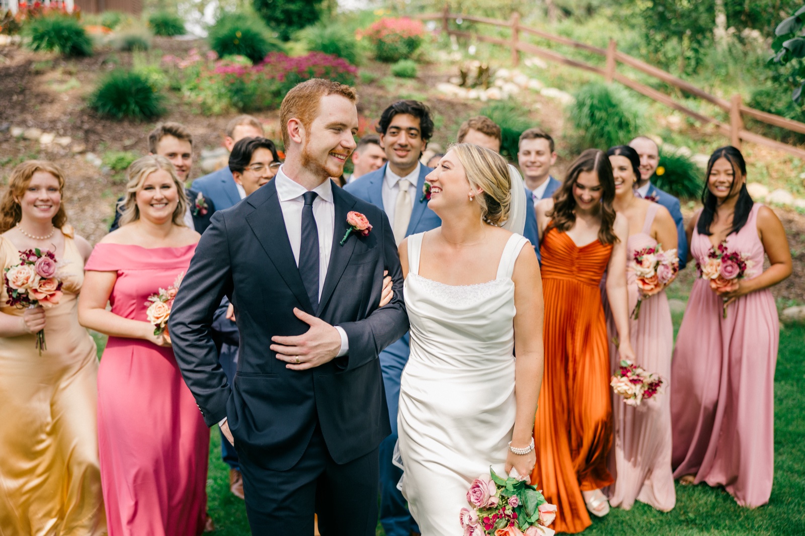 Monika and Mats laugh at the center of their bridal party as the group walks down a garden path at Grand View Lodge — Tim Larsen Photography, Brainerd Lakes MN