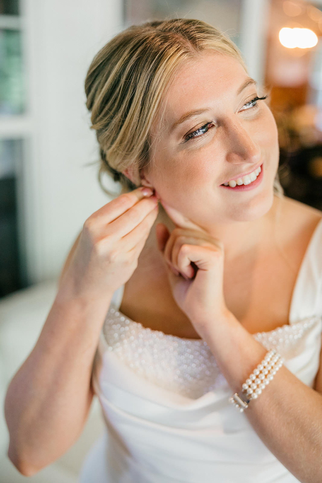 Bride putting on pearl earrings — bridal portrait at Grand View Lodge — Tim Larsen Photography, Brainerd Lakes MN