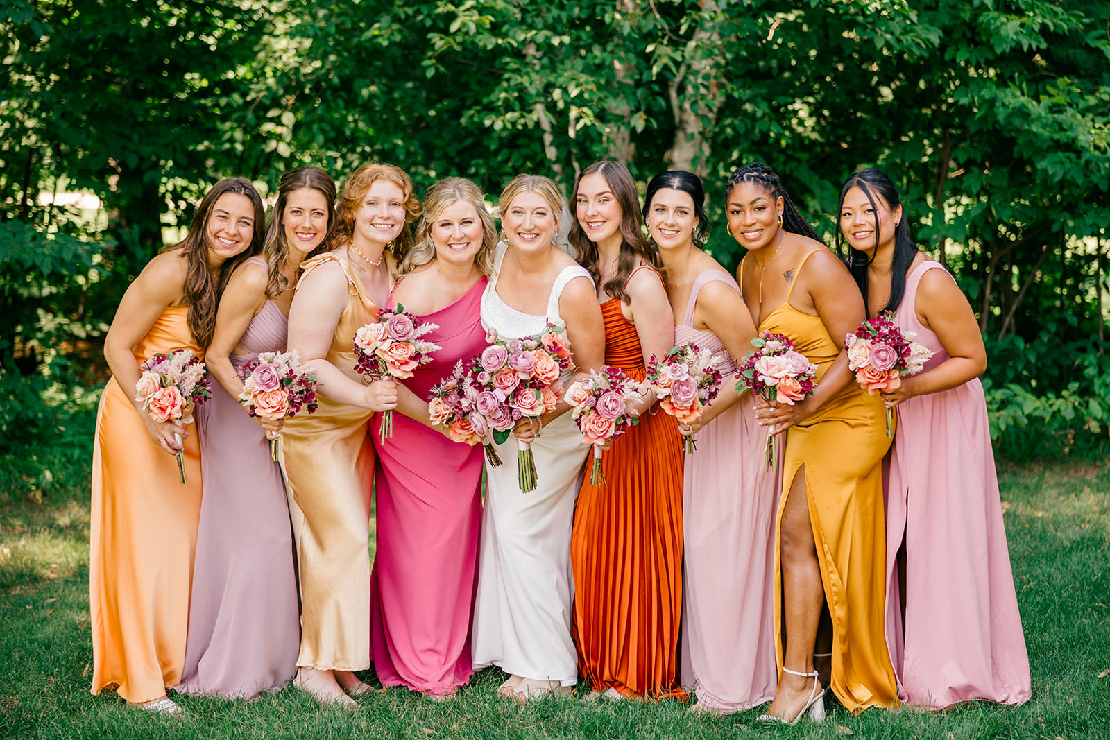 Bridesmaids in warm-toned dresses with coordinating bouquets at Grand View Lodge — Tim Larsen Photography, Brainerd Lakes MN