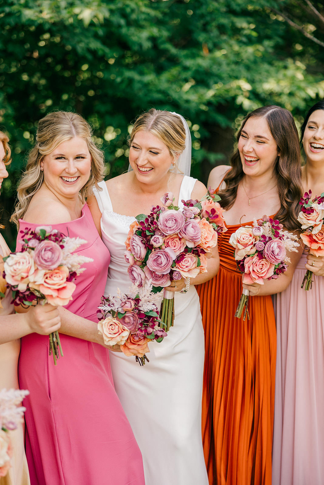 Bride laughing with bridesmaids — pink, orange, and gold dresses — Tim Larsen Photography, Brainerd Lakes MN
