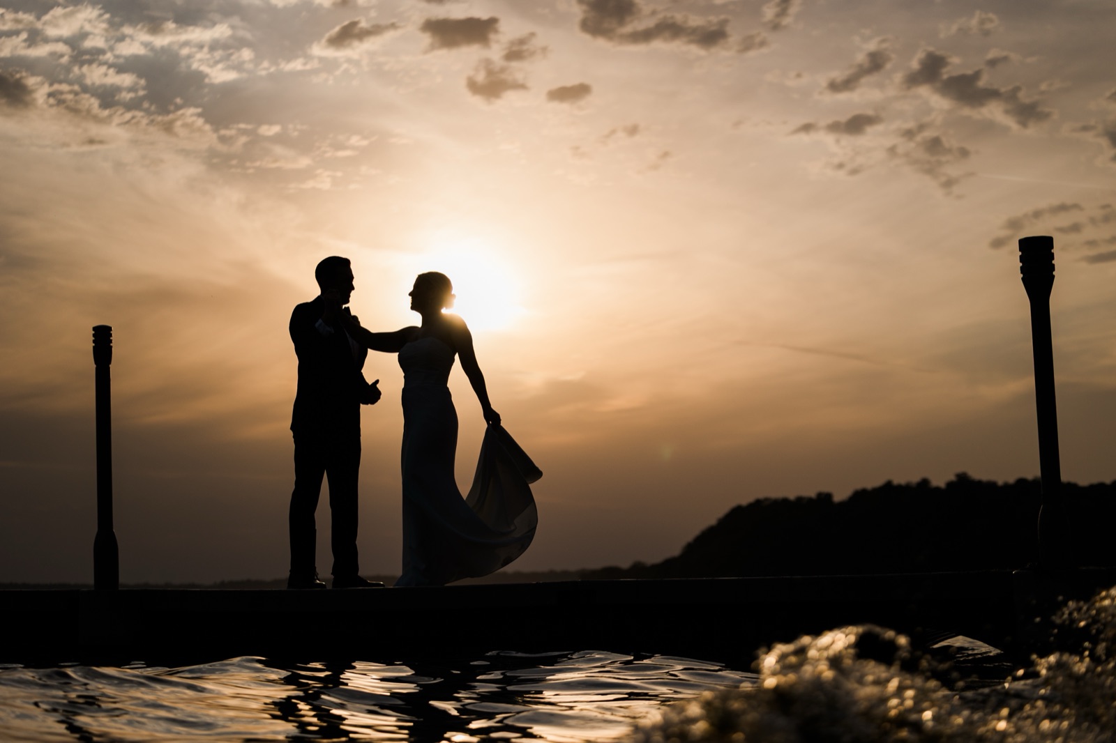 Sunset silhouette of couple between tiki torches on the dock at Grand View Lodge — Gull Lake golden hour — Tim Larsen Photography, Brainerd Lakes MN