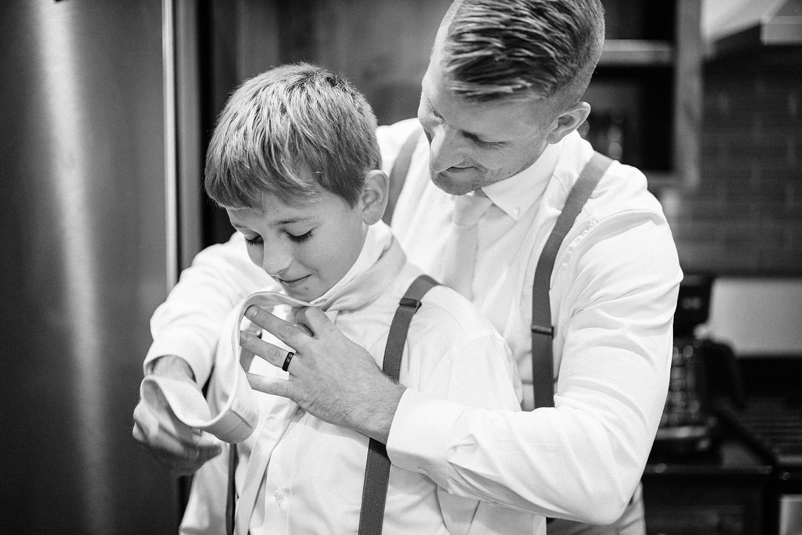 Jon helping his son with a bowtie — black and white getting ready moment — Tim Larsen Photography, Brainerd Lakes MN