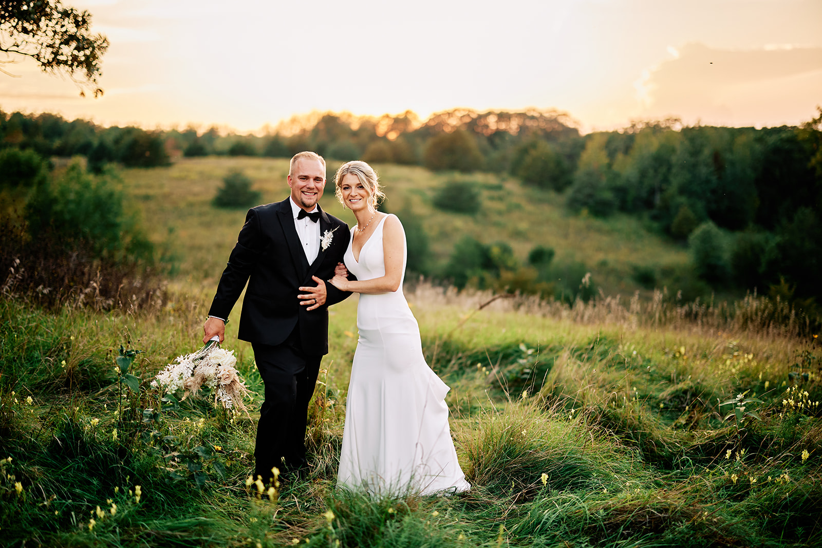 Golden hour portrait of couple walking through a wildflower field at sunset — Tim Larsen Photography, Brainerd Lakes MN