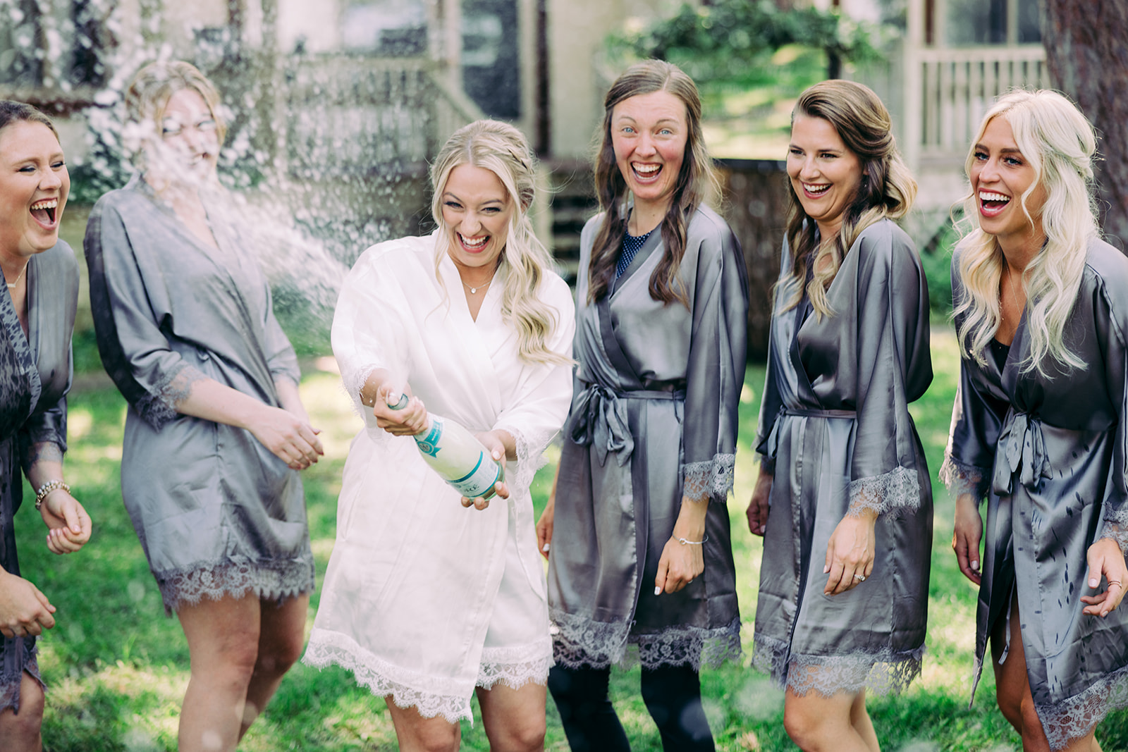 Bride popping champagne with her bridesmaids in matching robes — Tim Larsen Photography, Brainerd Lakes MN
