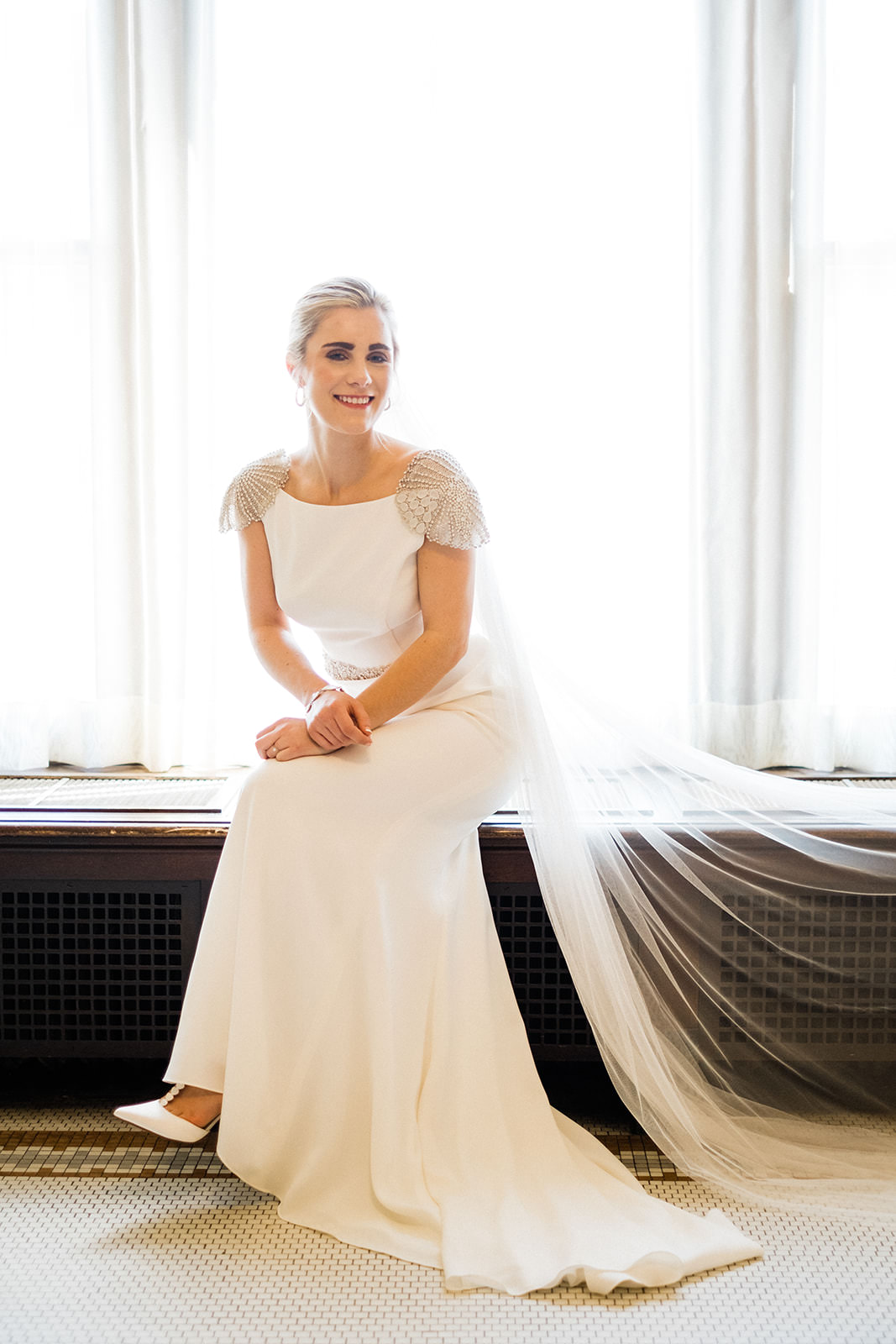 Bridal portrait by the window — bride seated with cathedral veil in natural light — Tim Larsen Photography, Brainerd Lakes MN